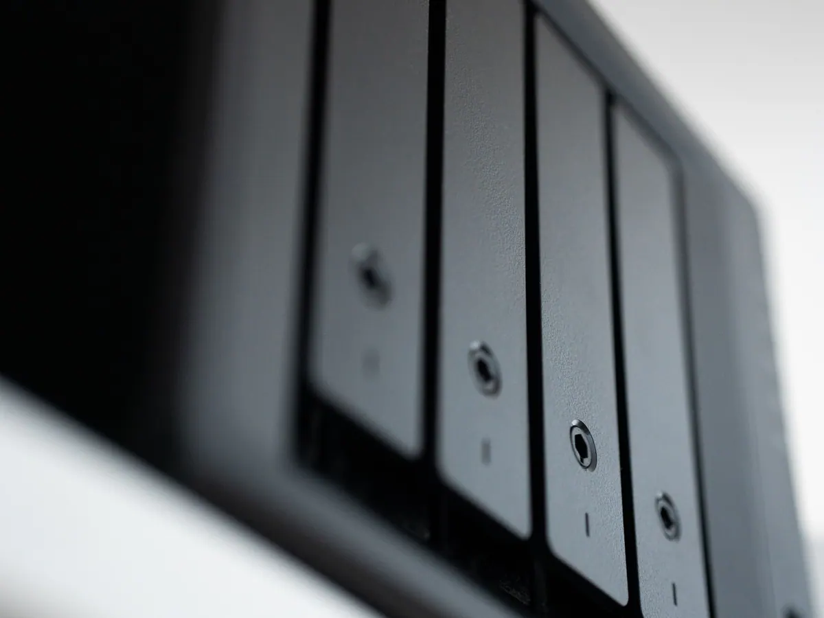Close-up of the drive bays on a small storage server against a white wall