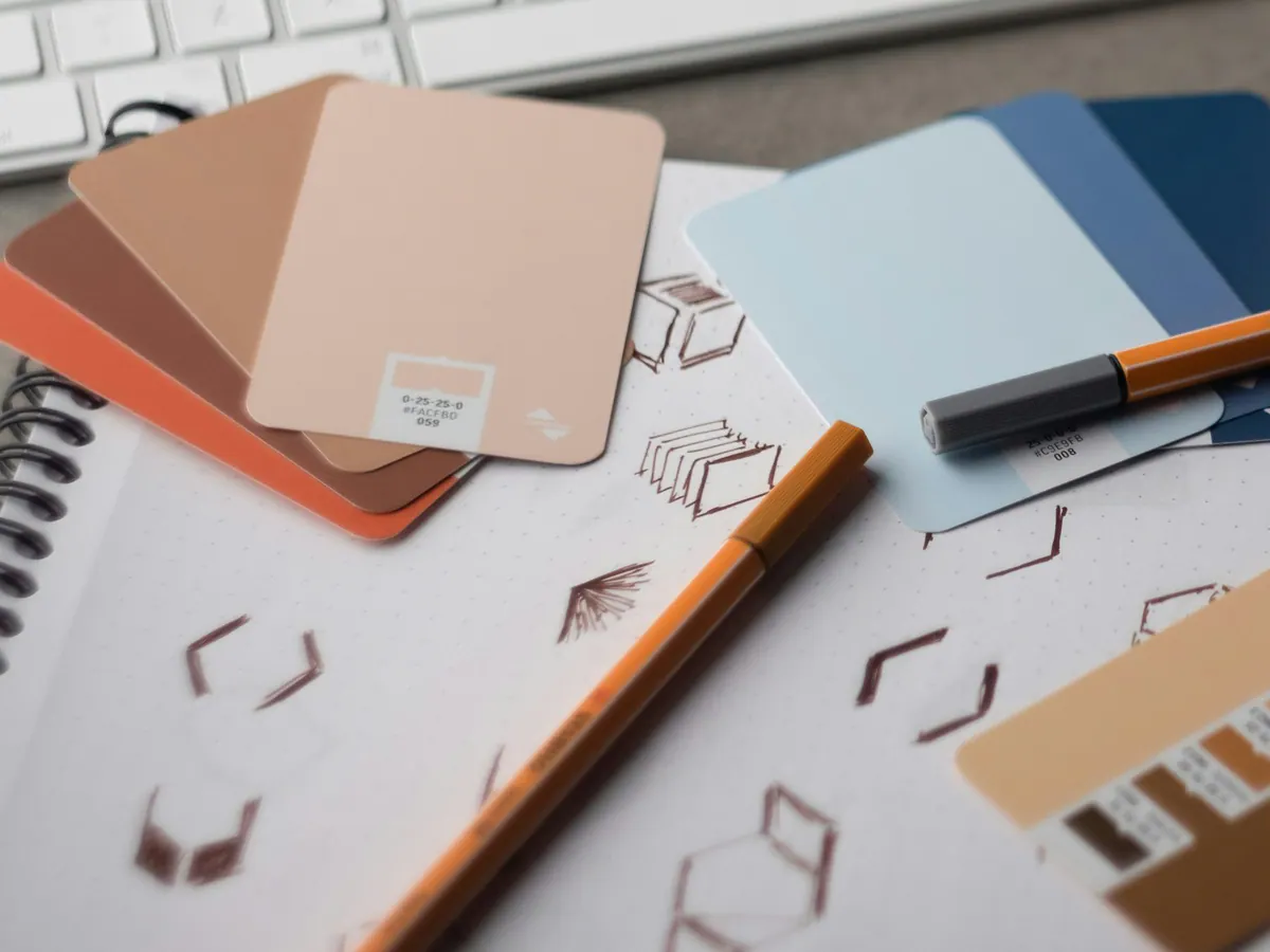 Colour swatches, fineliners and sketched shapes on a design notebook