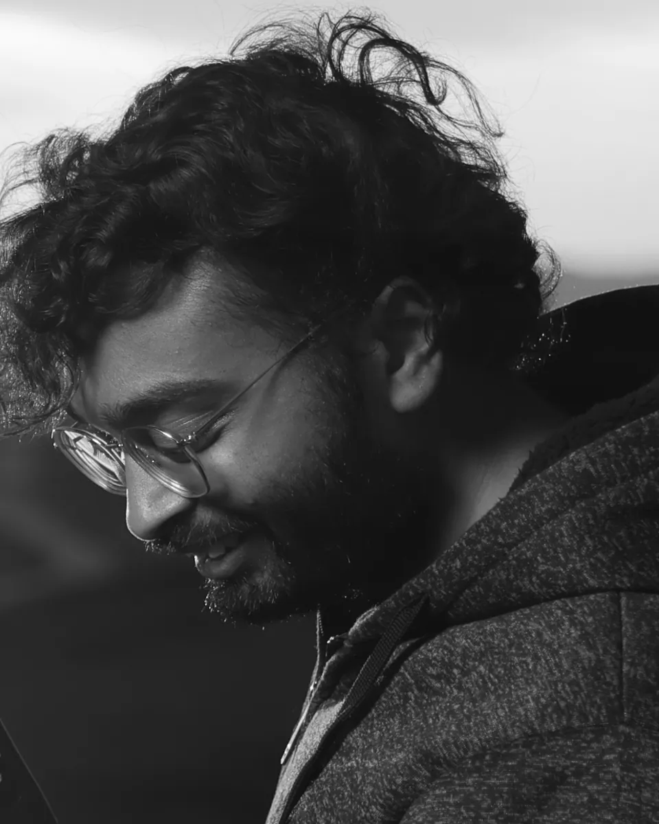 Siddharth Agrawal in black and white, smiling and looking down