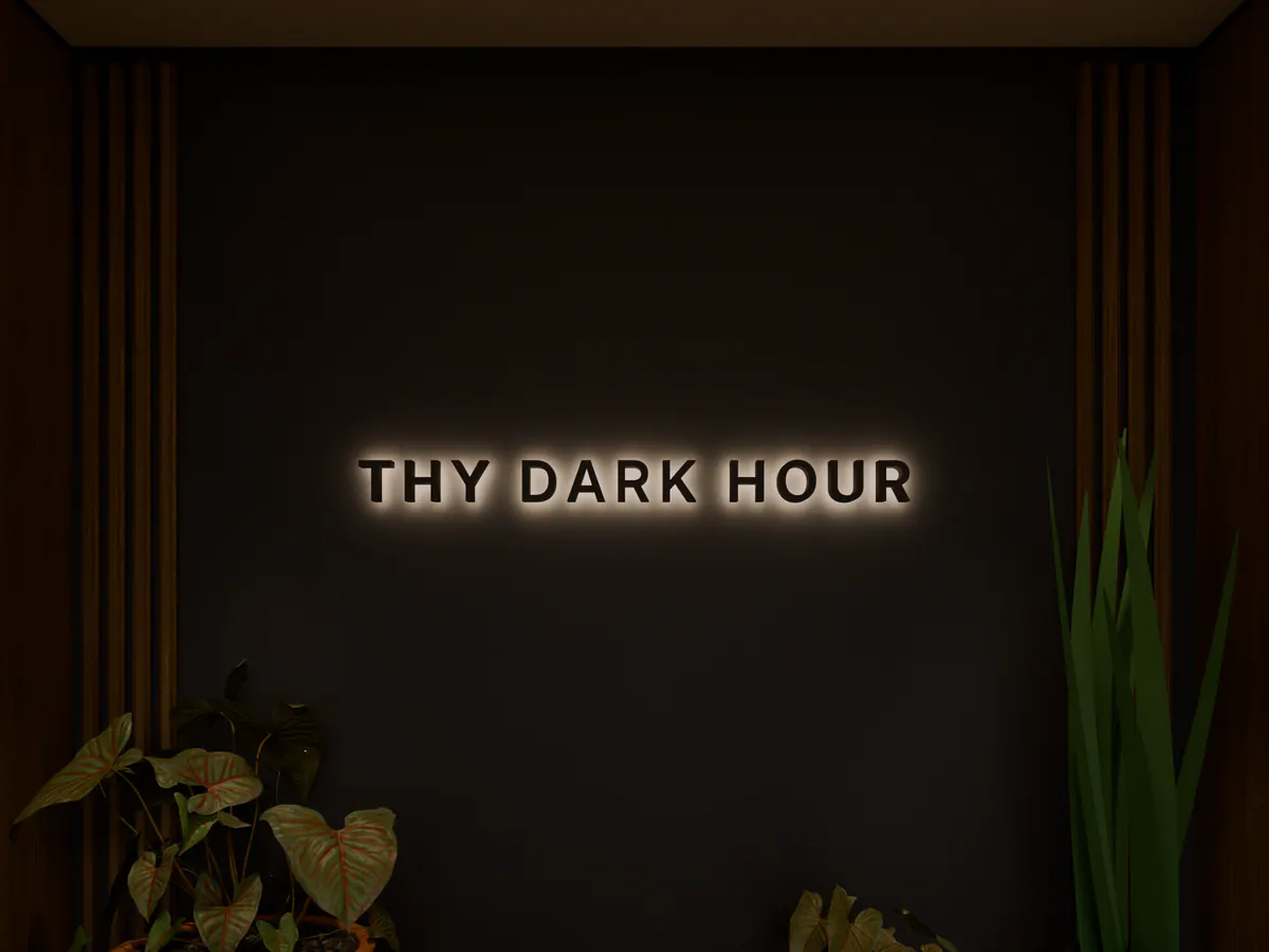 Close view of a halo-lit sign on a dark panel between wooden slats, with plants in front.